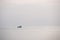 Silhouette minimalist of single fishery boat float on calm sea