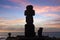 Silhouette of Moai heads near the Ahu Tahai Ceremonial complex on Easter Island, against a colorful sky.