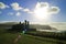 Silhouette of Moai statues with the dazzling sun and wavy Pacific ocean in the backdrop, Ahu Tongariki, Easter Island, Chile