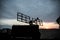 Silhouette of mobile air defence truck with radar antenna during sunset. Satellite dishes or radio antennas against evening sky