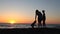 Silhouette of mom and son at sunset beach sea ocean