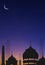 Silhouette Mosques Dome and Crescent Moon on dark blue Twilight sky in vertical frame, background design for Ramadan holy month