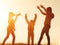 Silhouette of mother and daughters playing and having fun at sunset