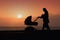 Silhouette mother pulling baby stroller