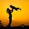 Silhouette of a mother and son who play outdoors at sunset