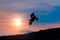 Silhouette of a motorbike rider stunting on sunset