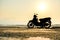 Silhouette a motorbike stands on the beach