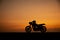 Silhouette of motorcycle parking with sunset background
