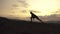 Silhouette of muscular bodybuilder with perfect body posing at the sunrise or sunset in mountains. Handsome strong man