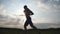 Silhouette of muscular man jogging in the country road at sunset. Profile of male jogger training for marathon run