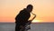 The silhouette of a musician playing saxophone on