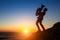 Silhouette of musician playing the trumpet on rocky sea coast during sunset.