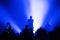 silhouette of musicians on stage in the light of a blue spotlight. atmosphere of a music festival with a dancing crow