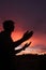 Silhouette of a muslim man praying on the desert