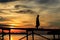 Silhouette Muslim man walk on the wooden jetty