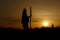 silhouette of native american shaman with pikestaff on background of sunset beutiful in mountains