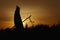 silhouette of native american shaman with pikestaff on background of sunset beutiful in mountains