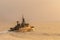 Silhouette of Navy corvette sails in the sea with golden light brace upon the sea surface