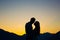 Silhouette of a newlywed couple on the background of the setting sun