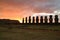 Silhouette of nine of 15 huge Moai statues at Ahu Tongariki against orange color sunrise sky, Easter Island, Chile