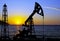 Silhouette of oil derricks on a sunset background. Oil and gas production concept. With place for your text