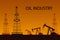 Silhouette of oil or gas drilling rigs on a sunset background.