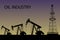 Silhouette of oil or gas drilling rigs on a sunset background.