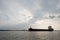 Silhouette Oil and Gas ship ride across the river with sunset sky as a background.