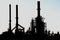 Silhouette of an oil refinery with chimneys