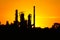 Silhouette of oil refinery factory against sunset