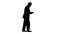 Silhouette Old elder senior man walking and texting on mobile smart phone.