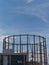 Silhouette of an old gasholder at sunset against blue sky