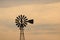 Silhouette of an old windmill on a farm in a golden sunset. Barker in Uruguay