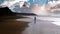 Silhouette of one lonely kite surfer on remote empty black lava sand beach, morning sunrise -  Ajuy, Fuerteventura, Canary Islands