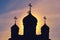 The silhouette of an Orthodox church with crosses on the domes. sunrise at the religious building