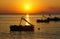 Silhouette of the paddle boat during the beautiful sunset on the seacoast