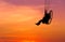 Silhouette paraglider flying on sunset