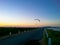 Silhouette of paragliding flying over dam