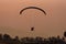 Silhouette of the Paramotor gliding and flying In the air through soft sunlight sky