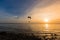 Silhouette of Paramotors flying to sky on sunset