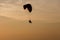 Silhouette of Paramotors flying to sky on sunset Adventure man active extreme sport pilot flying in sky with paramotor engine glid