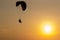 Silhouette of Paramotors flying to sky on sunset Adventure man active extreme sport pilot flying in sky with paramotor engine glid
