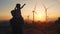 Silhouette of Parent and Child against Sunset with Wind Turbines. Family Enjoying Renewable Energy Scenery. Emotional