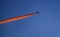 Silhouette of a passenger aircraft in the sky with an inversion trail. The plane takes off at sunset. Abstract composition