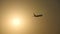 Silhouette of passenger airplane flies across sun at sunset. Plane taking off at sunrise background. Aircraft crossing