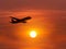 Silhouette passenger airplane flying away in to sky on sunset