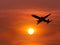 Silhouette passenger airplane flying on sunset