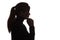 Silhouette of a pensive sad girl with hand under chin , young woman on white isolated background thinking about problem