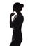 Silhouette of a pensive woman with the hand at the chin on a white isolated background, girl make a decision