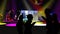 Silhouette of people dancing with colorful spotlights